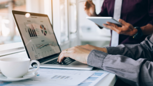 Entrepreneurs analyzing small business financial data and private lending options on a laptop and tablet