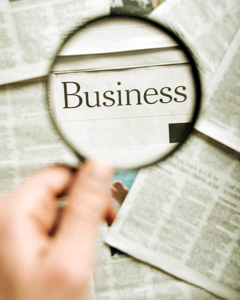 Close-up of the word “Business” under a magnifying glass, symbolizing analysis and rescue tools.
