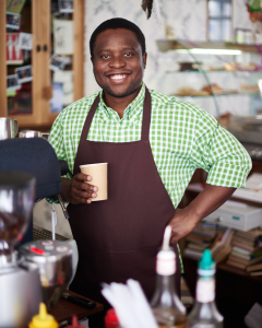 Minority coffee shop owner smiling confidently thanks to nontraditional business loans